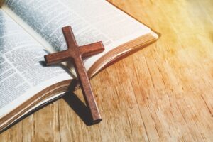wooden cross resting on an open Bible